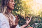 Mature Woman Meditating in Forest.