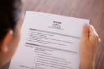 A photo of a man holding a resume.