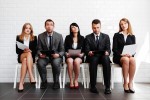 A group of people in business attire sitting on chairs.