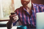 A man reading something on a cell phone.