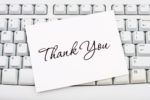 A "thank you" greeting card on top of a keyboard.