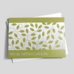 A green leaf greeting card design on top of a matching envelope on a gray background.